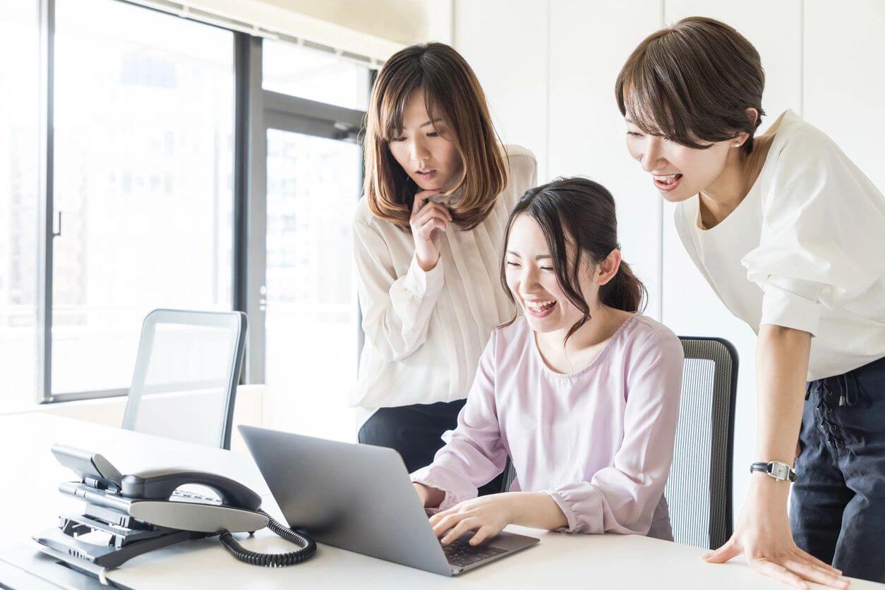 Three women looking at a laptop screen